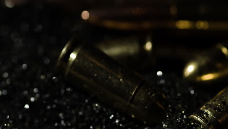 close-up of 9mm and 300 blk out bullets cascading down in slow motion, with a dark, moody backdrop