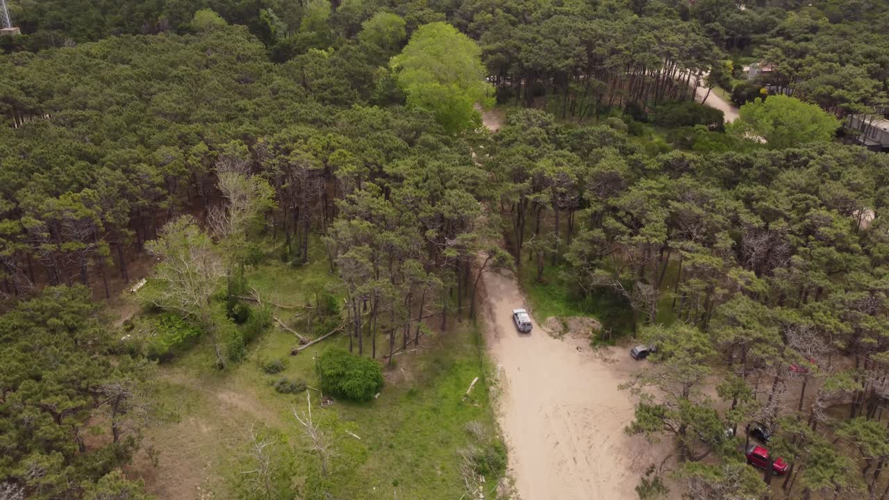 vehículo blanco de cuatro ruedas conduciendo por caminos sin pavimentar en el bosque en mar de las pampas en argentina