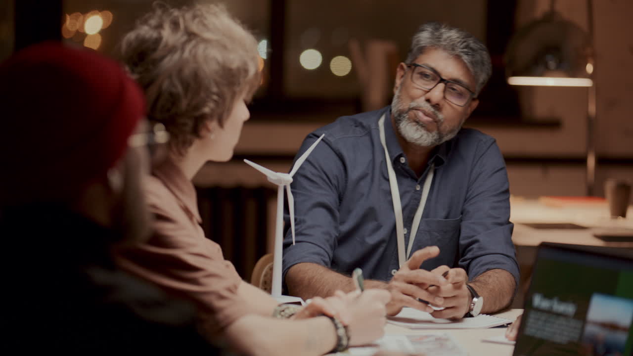 ingeniero maduro discutiendo estrategias de energía renovable con el equipo