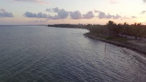 Vuelo-De-Drones-Sobre-Un-Muelle-Al-Atardecer-En-Un-Pueblo-Pesquero-Del-Caribe