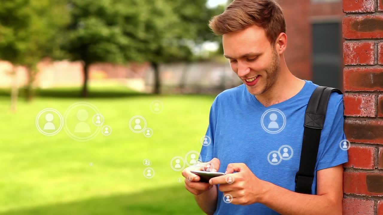 estudiante caucásico en camisa azul jugando en el teléfono móvil