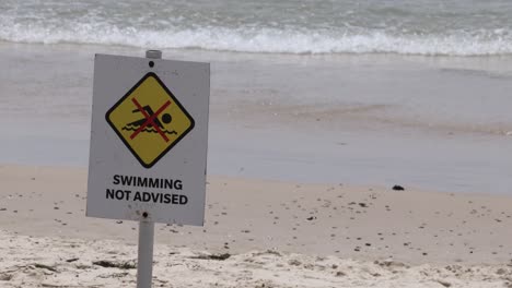 sign warning against swimming at a beach