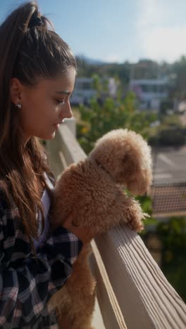 woman and her puppy on a balcony