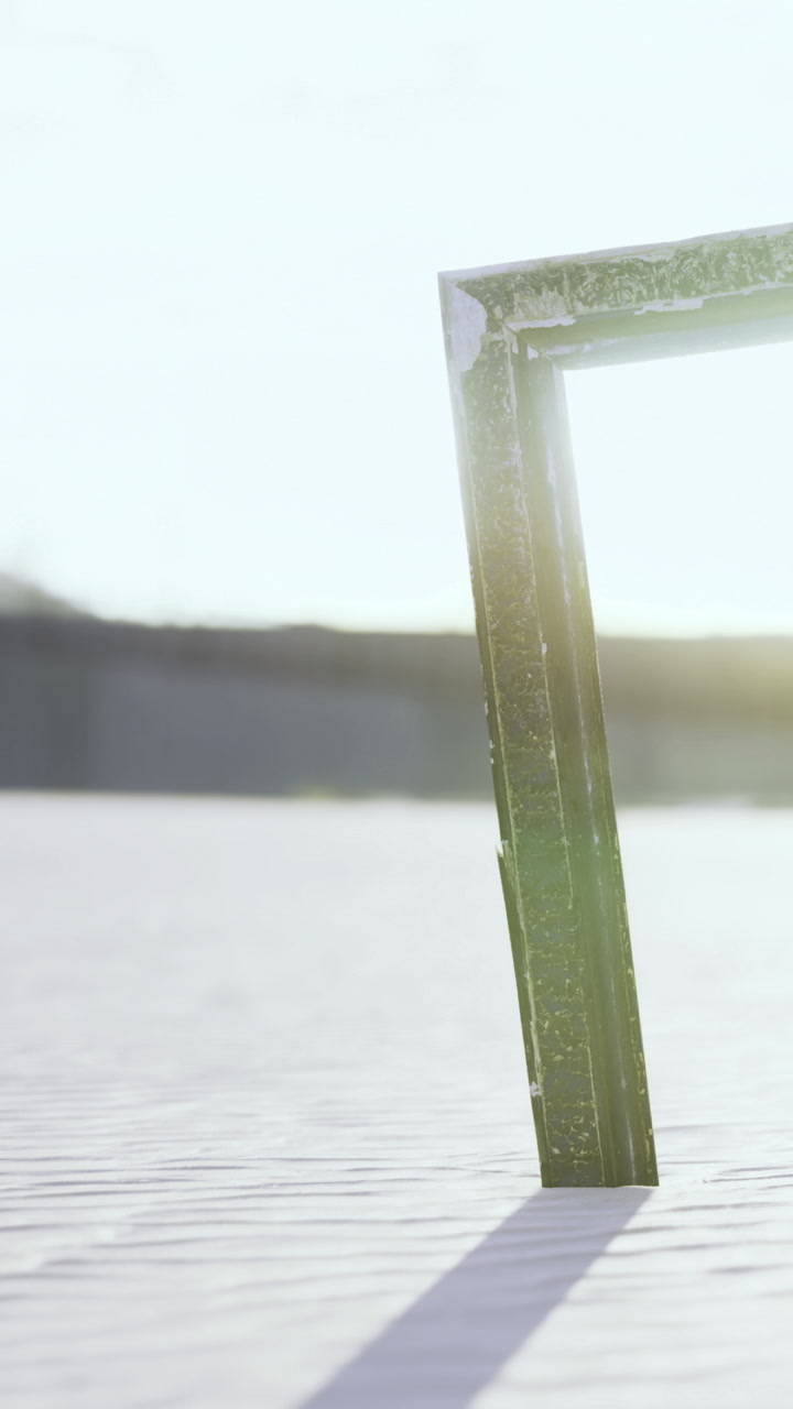 Sunlight shines on a metal frame placed on sand at a beach in the afternoon