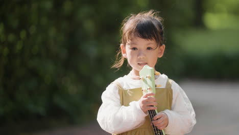 child with musical instrument outdoors