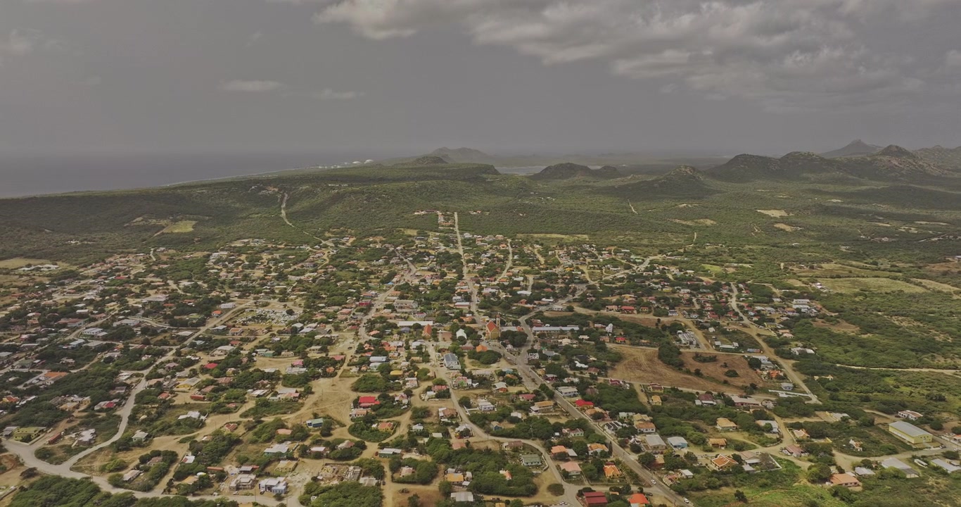 Bonaire Caraibi Olandesi Aerea v82 sorvolo inverso sopra Rincon, che rivela il paesaggio urbano residenziale, il parco e le aspre colline dell'isola - Ripreso con Mavic 3 Pro Cine - 3 febbraio 2024