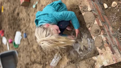 little girl playing in a sandbox