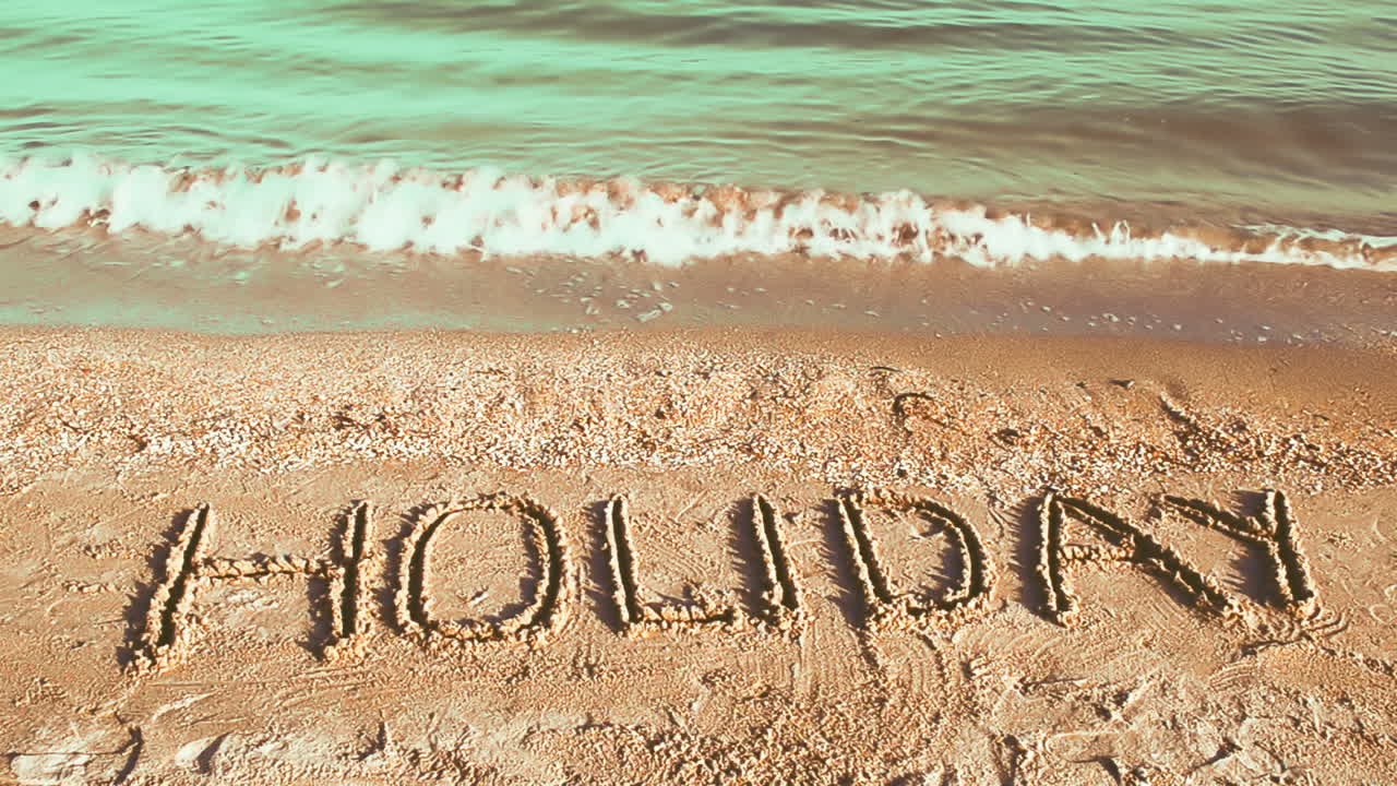 Inscription Holiday on sand, the beach. Shooting on the beach