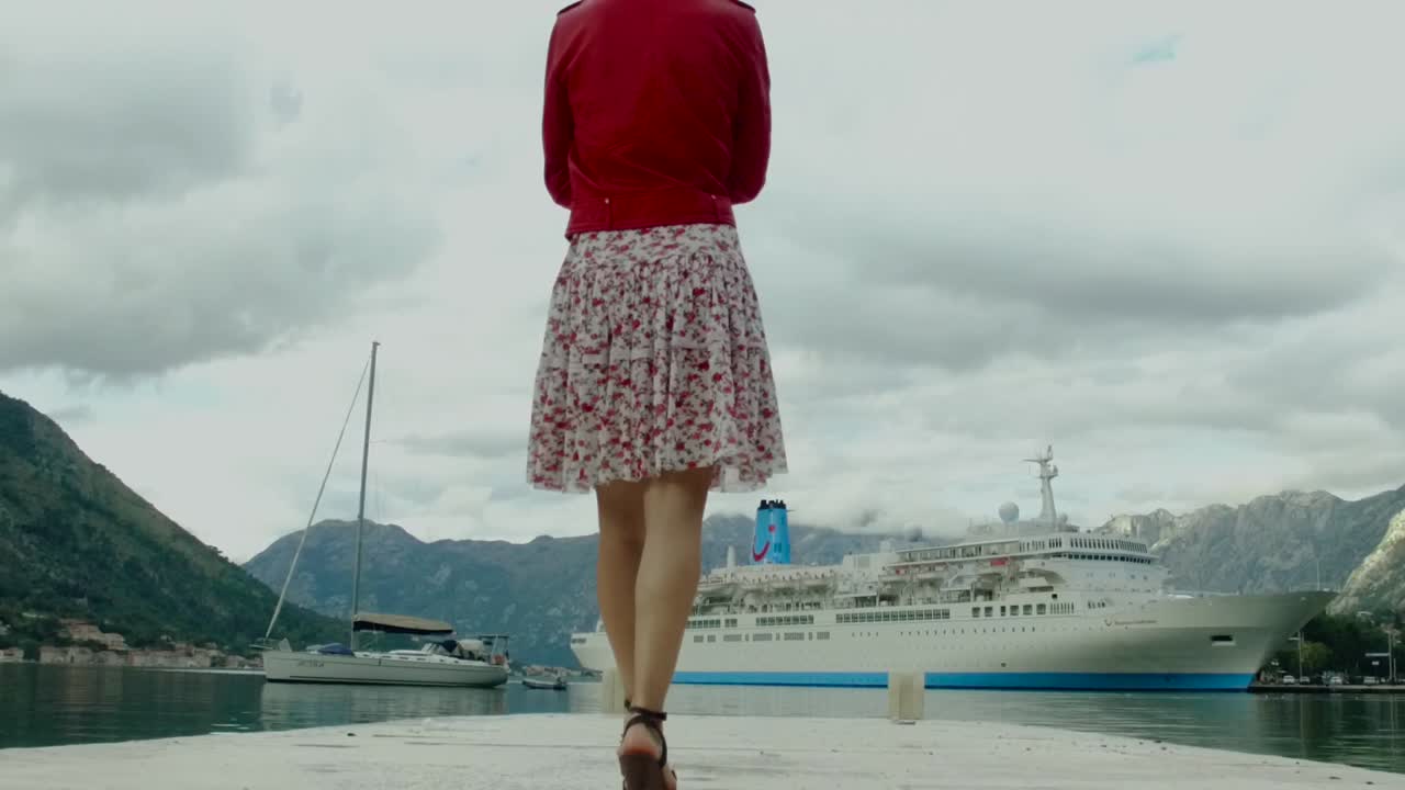 mujer caminando en un muelle por un crucero