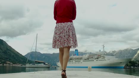 woman walking on a dock by a cruise ship