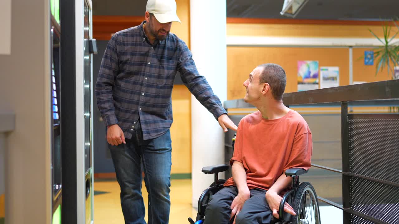 Man in wheelchair with friend at vending machine