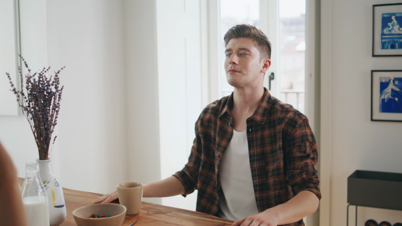 Husband fooling around wife during home breakfast. Girl throwing berry food