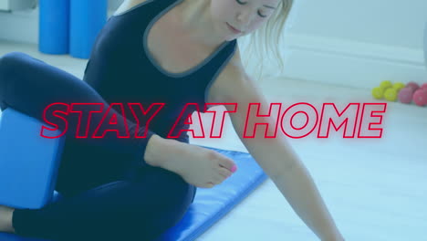 animation of colourful neon words stay at home over caucasian woman stretching