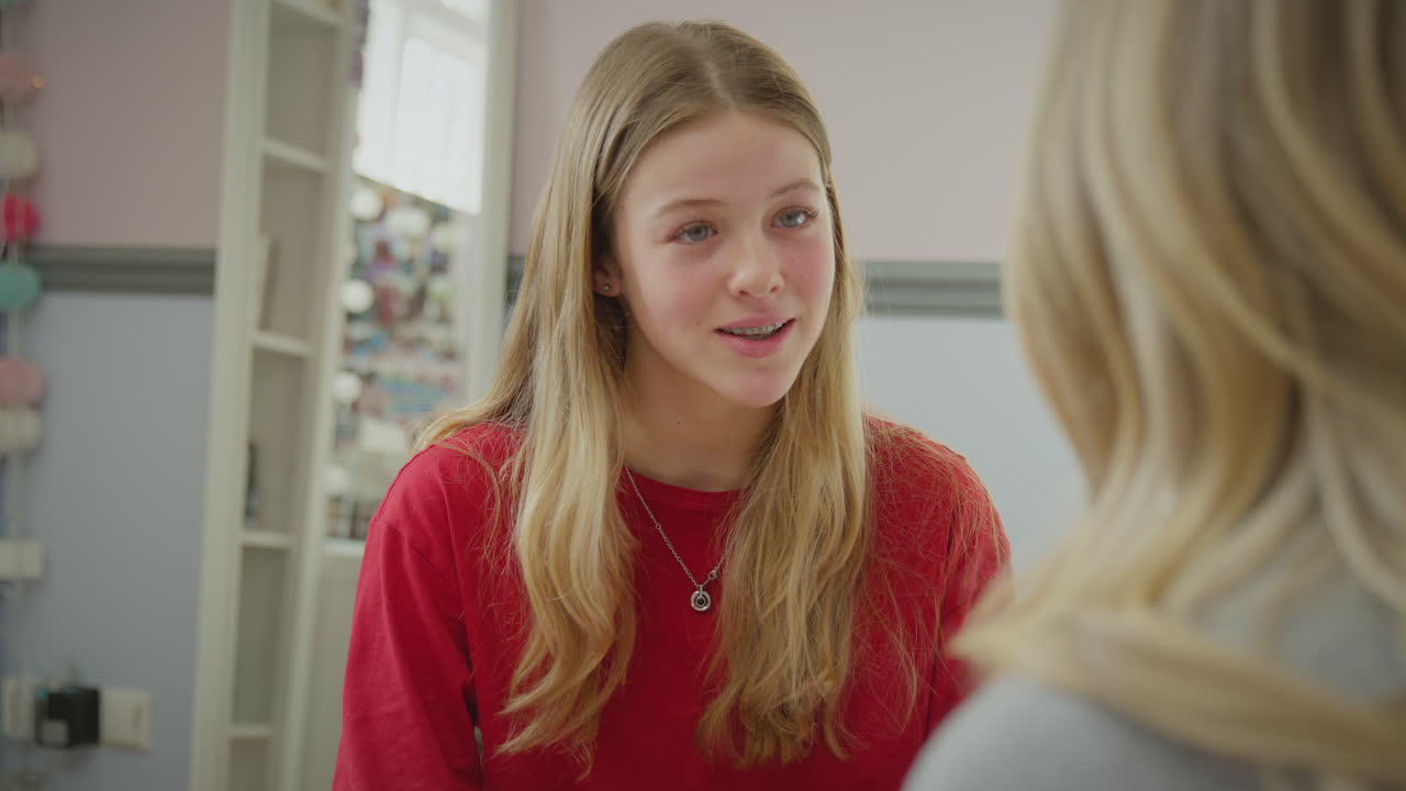 잠옷을 입은 십대 딸이 침대에 앉아 침실에서 어머니와 대화하고 있는 모습 - 느린 동작으로 촬영