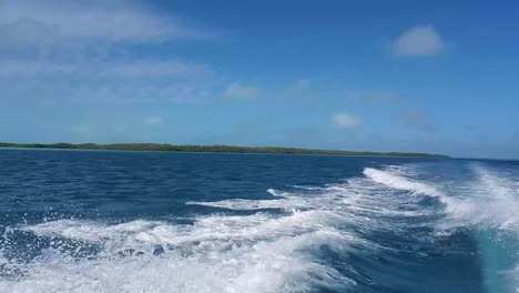 ondas pov generadas por lancha motora navegando en el agua, salpicadura de ángulo bajo en la superficie del mar