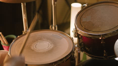 unrecognizable male musician playing drums during a band rehearsal in recording studio 4