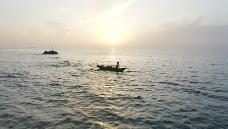 local fisherman in traditional boat near shore of sri lanka at dawn