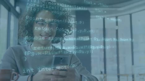 animación del procesamiento de datos contra un hombre biracial sonriendo mientras usa un teléfono inteligente en la oficina