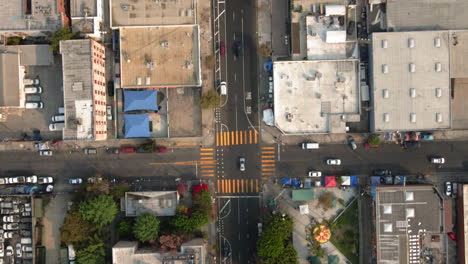 aerial view of an urban landscape featuring a street intersection, commercial buildings, and a public park with recreational facilities