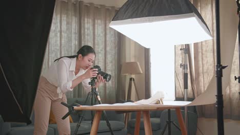 asian female photographer being tired taking photos of women's shoes in home studio