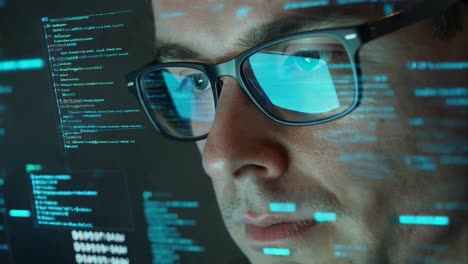 close-up of man's eyes reflected in screen with code