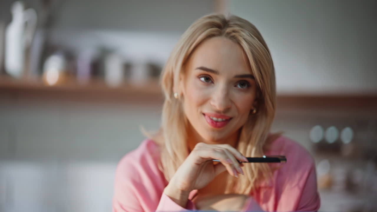Smiling writer holding pen feeling inspiration at home portrait. Happy blonde