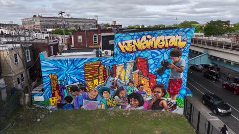 vibrant street art mural depicting children and cityscape in kensington