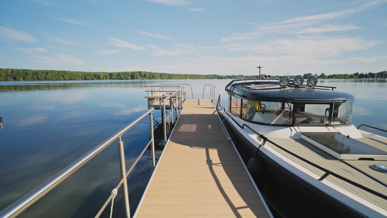 Gehen auf einem Holzsteg in Richtung See, vertäute Yacht an einem Sommertag – Gimbal-Aufnahme auf Augenhöhe mit Vorwärtsbewegung