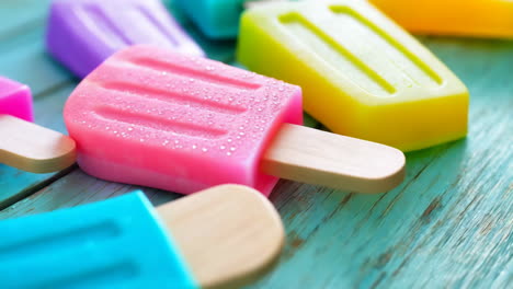 colorful popsicles on a wooden surface