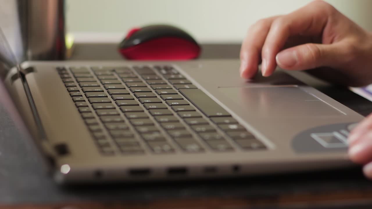 Clouse up of a hands turning on a laptop and typing