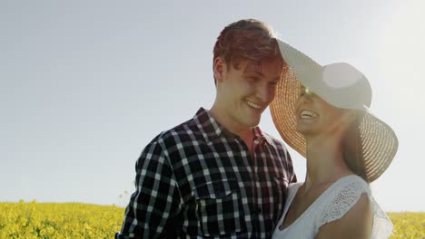 romantic couple embracing each other in mustard field