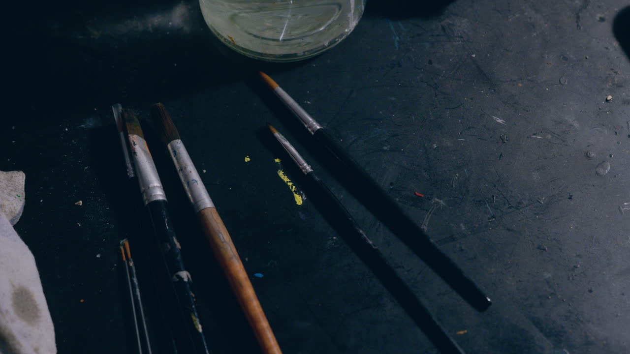 el hombre del taller de pintura elige un pincel en cámara lenta