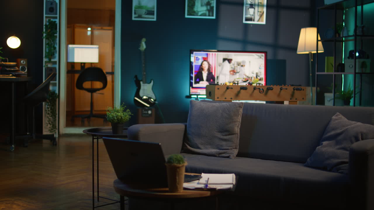 Cozy modern apartment decorated with neon lights and a big tv, home theatre and setup for a young adult. Empty loft studio illuminated and equipped with electronics, comfortable space.