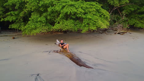 Rotating-aerial-view-of-caucasian-women-relaxing-on-deserted-beach-during-sunset-in-Costa-Rica