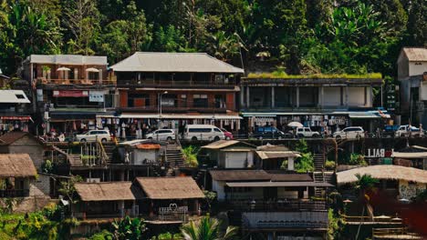 a small mountain village near ubud in bali with cars and small shops