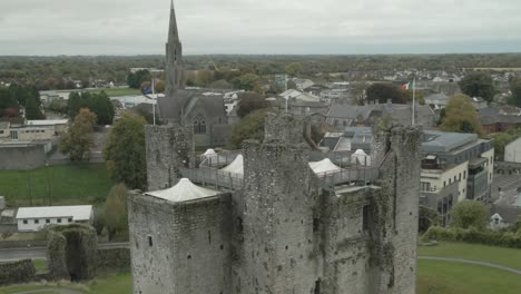 flags on the tower of trim castle with st. patricks church in the distance in county meath, ireland. - aeriala shot