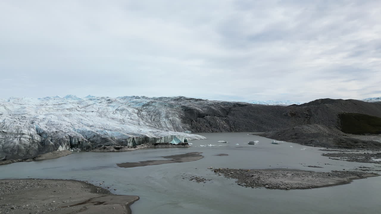 Establishing drone shot of the Russell glacier, cloudy summer day in Greenland