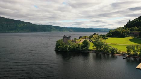 Centinela-Del-Lago:-Los-Históricos-Muros-Del-Castillo-De-Urquhart,-Vistas-Aéreas-Desde-El-Lago-Ness-En-Las-Tierras-Altas-De-Escocia