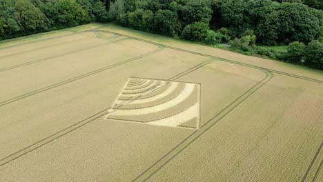 aerial view circling towards micheldever curving wave crop square on hampshire wheat field 2023