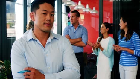 business executive standing with arms crossed in office