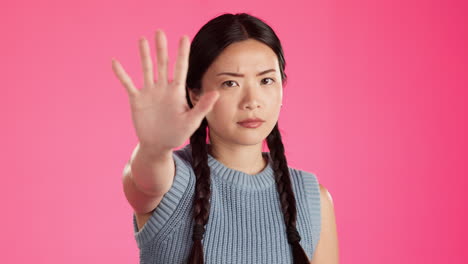 Asian-woman,-face-or-stop-hands-isolated-in-studio