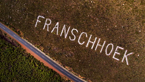 Aerial-descent-over-Franschhoek-place-name-on-mountainside-of-pass