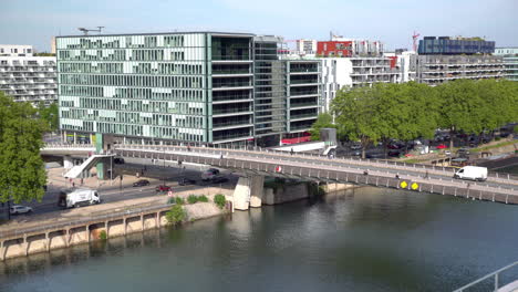 Static-shot-of-pedestrians-and-cars-crossing-a-bridge-over-the-river-Seine-in-Paris,-France