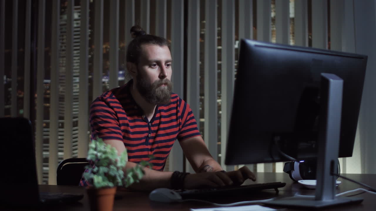 Bearded Man Working on Computer at Night