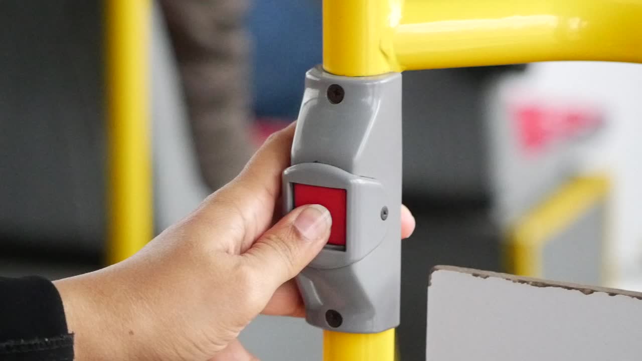 pasajero presionando el botón de emergencia en un autobús