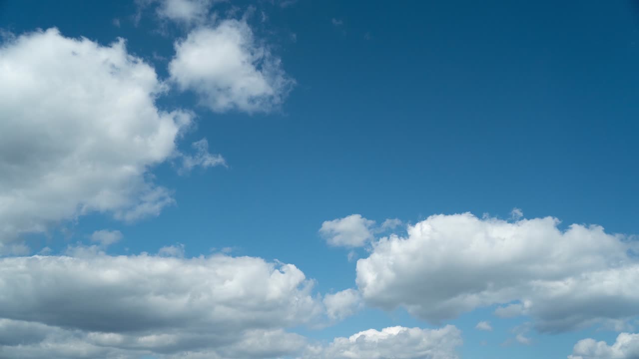 uhd lapso de tiempo de nubes cumulus peludas blancas que fluyen de izquierda a derecha en el cielo azul