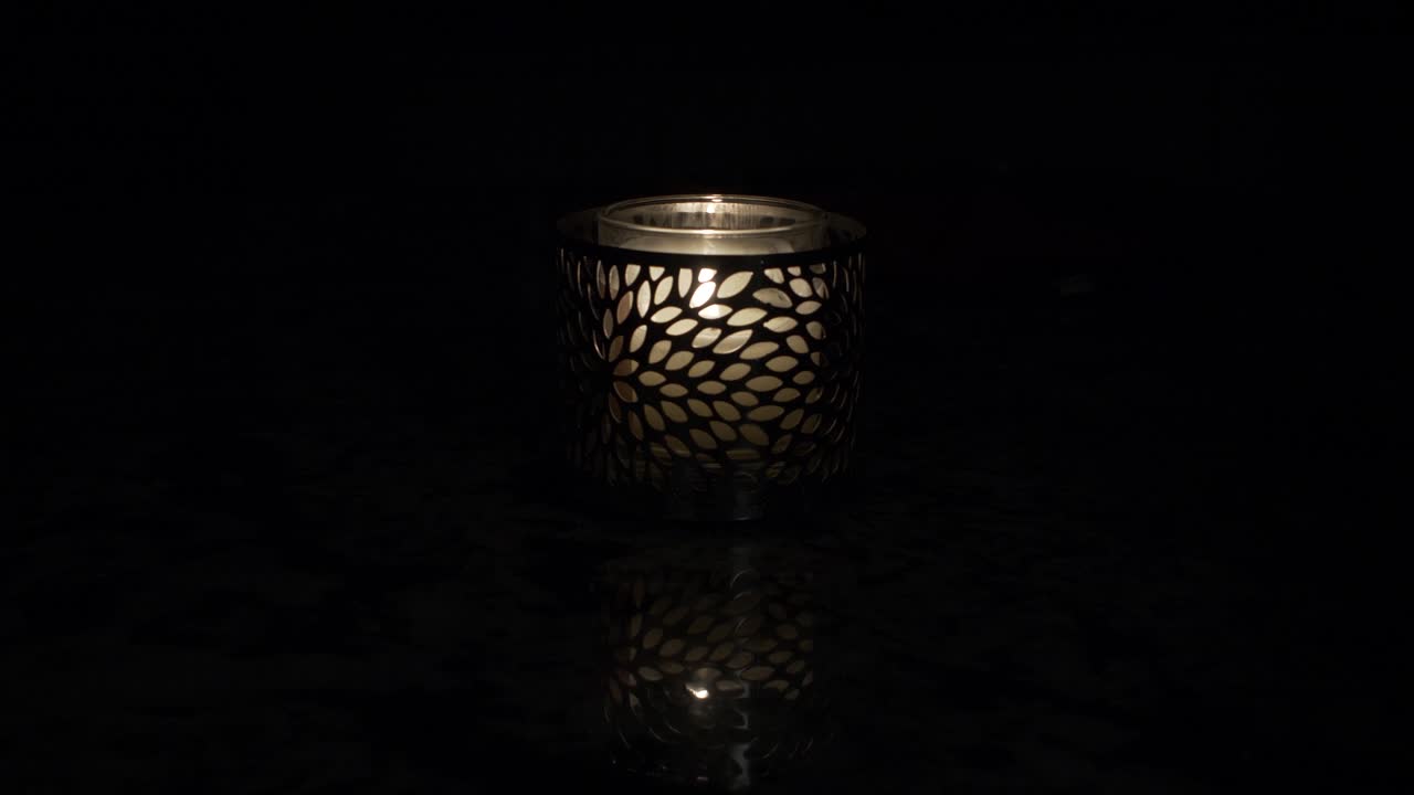 하나의 불꽃이 깜박이는 어두운 조명의 테이블 위의 촛대