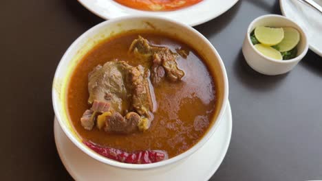 assortment of chicken rogan josh with a oily orange lacha paratha looking delicious.