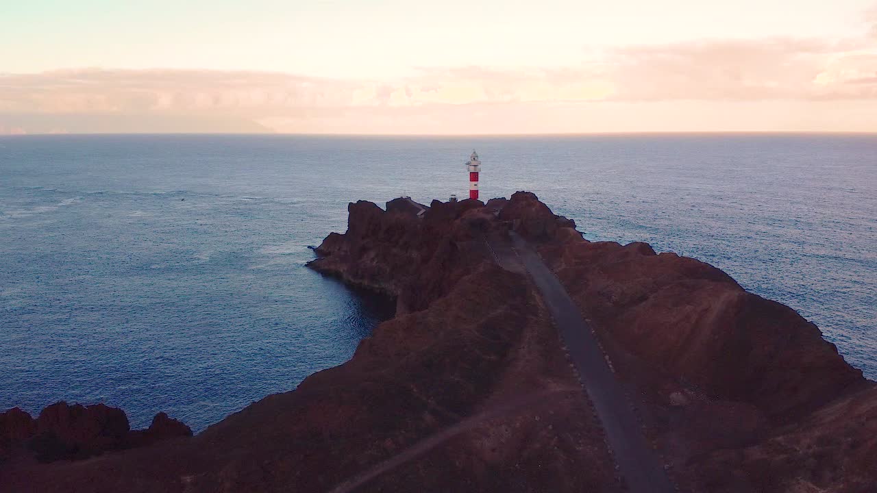 Majestic lighthouse on rocky cliffside in Tenerife island, aerial drone view