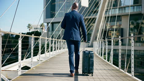 businessman walking on a bridge with suitcase